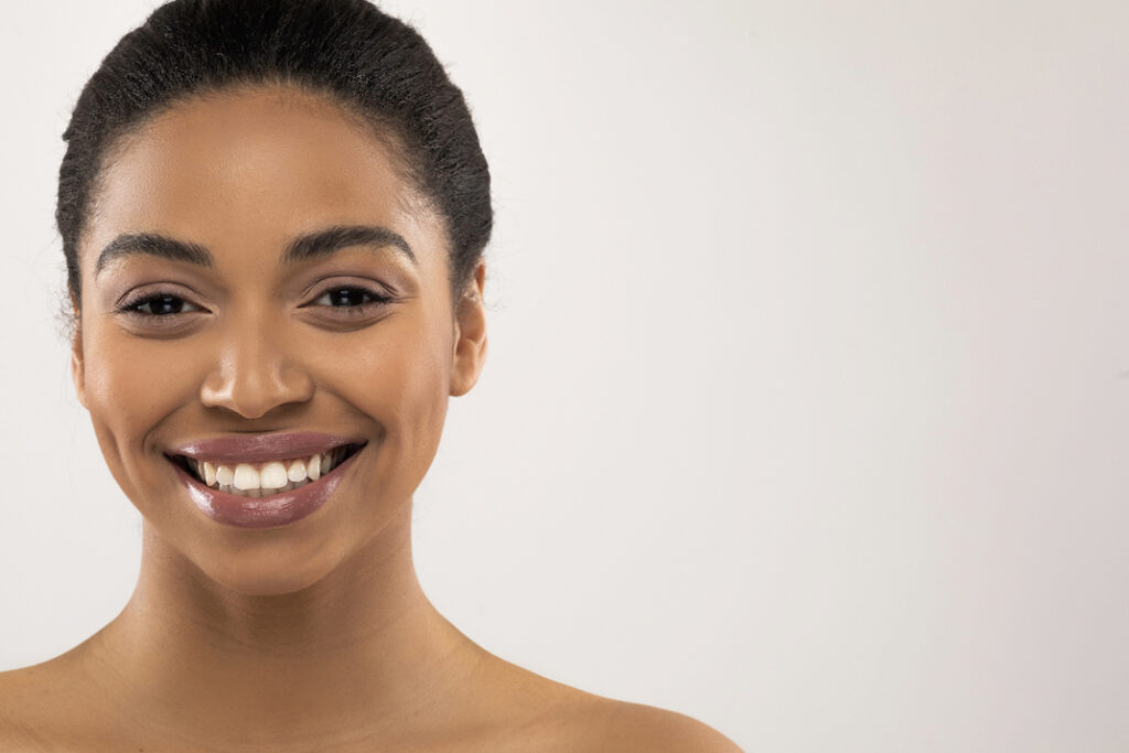 closeup of cheerful young African American woman smiling at camera after Blepharoplasty surgery