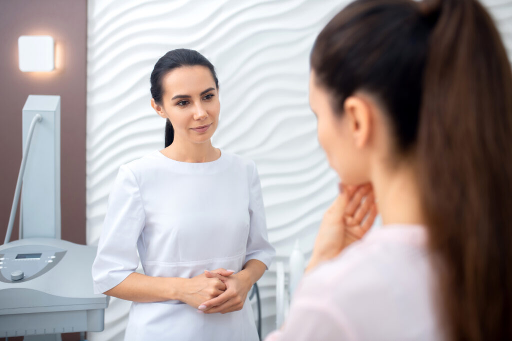 Attentive plastic surgeon listening to her patient telling about problems
